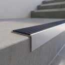 Slimline 59x30mm square back aluminium stair nosing with a regency slate-blue ribbed PVC insert, on a satin aluminium bar, fitted along the front edge of a concrete step