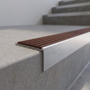 Slimline 59x30mm square back aluminium stair nosing with a rustic rust-brown ribbed PVC insert, on a satin aluminium bar, fitted along the front edge of a concrete step