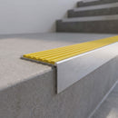 Slimline 59x30mm square back aluminium stair nosing with a bright yellow ribbed PVC insert, on a satin aluminium bar, fitted along the front edge of a concrete step