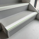 60x55mm aluminium stair nosing with white insert and green glow strip fitted to grey vinyl office stairs