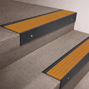 Black Anodised finish 66x55mm raked back aluminium stair nosing with a Gold Castellated insert, fitted to interior steps