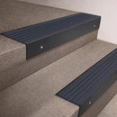 Black Anodised finish 66x55mm raked back aluminium stair nosing with a Granite Castellated insert, fitted to interior steps