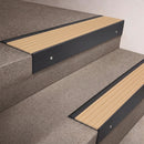 Black Anodised finish 66x55mm raked back aluminium stair nosing with a Porth Stone Castellated insert, fitted to interior steps