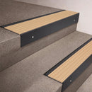 Black Anodised finish 66x55mm raked back aluminium stair nosing with a Porth Stone Castellated insert, fitted to interior steps