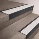 Black Anodised finish 66x55mm raked back aluminium stair nosing with a White Castellated insert, fitted to interior steps