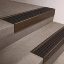 Bronze finish 66x55mm raked back aluminium stair nosing with a Black Castellated insert, fitted to interior steps