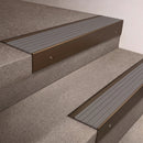 Bronze finish 66x55mm raked back aluminium stair nosing with a Flint Castellated insert, fitted to interior steps