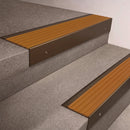 Bronze finish 66x55mm raked back aluminium stair nosing with a Gold Castellated insert, fitted to interior steps