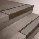 Bronze finish 66x55mm raked back aluminium stair nosing with a Light Grey Castellated insert, fitted to interior steps