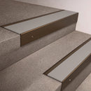 Bronze finish 66x55mm raked back aluminium stair nosing with a Light Grey Smooth Textured insert, fitted to interior steps