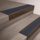 Bronze finish 66x55mm raked back aluminium stair nosing with a Mid Blue Castellated insert, fitted to interior steps