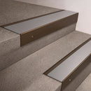 Bronze finish 66x55mm raked back aluminium stair nosing with a Mill Aluminium insert, fitted to interior steps