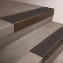 Bronze finish 66x55mm raked back aluminium stair nosing with a Nimbus Castellated insert, fitted to interior steps