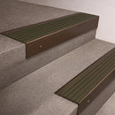 Bronze finish 66x55mm raked back aluminium stair nosing with a Olive Castellated insert, fitted to interior steps