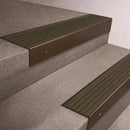 Bronze finish 66x55mm raked back aluminium stair nosing with a Olive Castellated insert, fitted to interior steps