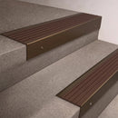 Bronze finish 66x55mm raked back aluminium stair nosing with a Peat Castellated insert, fitted to interior steps