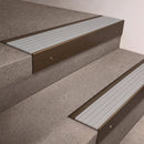 Bronze finish 66x55mm raked back aluminium stair nosing with a Polar Grey Castellated insert, fitted to interior steps