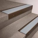 Bronze finish 66x55mm raked back aluminium stair nosing with a Polar Grey Smooth Textured insert, fitted to interior steps