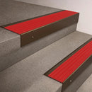 Bronze finish on a 66x55mm raked back aluminium stair nosing with a Poppy red insert, fitted to interior steps