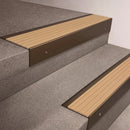 Bronze finish 66x55mm raked back aluminium stair nosing with a Porth Stone Castellated insert, fitted to interior steps