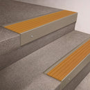 Light Bronze finish 66x55mm raked back aluminium stair nosing with a Gold Castellated insert, fitted to interior steps