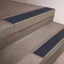 Light Bronze finish 66x55mm raked back aluminium stair nosing with a Granite Castellated insert, fitted to interior steps
