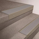 Light Bronze finish 66x55mm raked back aluminium stair nosing with a Light Grey Castellated insert, fitted to interior steps