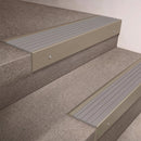 Light Bronze finish 66x55mm raked back aluminium stair nosing with a Light Grey Castellated insert, fitted to interior steps