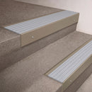 Light Bronze finish 66x55mm raked back aluminium stair nosing with a Polar Grey Castellated insert, fitted to interior steps