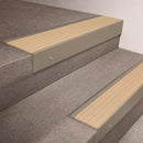 Light Bronze finish 66x55mm raked back aluminium stair nosing with a Porth Stone Castellated insert, fitted to interior steps