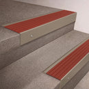 Light Bronze finish 66x55mm raked back aluminium stair nosing with a Rustic Castellated insert, fitted to interior steps