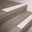 Light Bronze finish 66x55mm raked back aluminium stair nosing with a White Castellated insert, fitted to interior steps