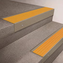Light Bronze finish 66x55mm raked back aluminium stair nosing with a Yellow Castellated insert, fitted to interior steps