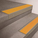 Light Bronze finish 66x55mm raked back aluminium stair nosing with a Yellow Castellated insert, fitted to interior steps