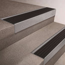 Mill Aluminium finish 66x55mm raked back aluminium stair nosing with a Black Castellated insert, fitted to interior steps