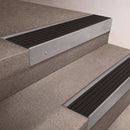 Mill Aluminium finish 66x55mm raked back aluminium stair nosing with a Black Castellated insert, fitted to interior steps