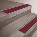 Mill Aluminium finish 66x55mm raked back aluminium stair nosing with a Claret Castellated insert, fitted to interior steps