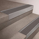 Mill Aluminium finish 66x55mm raked back aluminium stair nosing with a Flint Castellated insert, fitted to interior steps