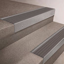 Mill Aluminium finish 66x55mm raked back aluminium stair nosing with a Flint Castellated insert, fitted to interior steps