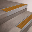 Mill Aluminium finish 66x55mm raked back aluminium stair nosing with a Gold Castellated insert, fitted to interior steps