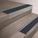 Mill Aluminium finish 66x55mm raked back aluminium stair nosing with a Granite Castellated insert, fitted to interior steps