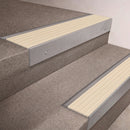 Mill Aluminium finish 66x55mm raked back aluminium stair nosing with a Ivory Castellated insert, fitted to interior steps