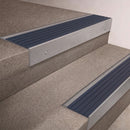 Mill Aluminium finish 66x55mm raked back aluminium stair nosing with a Mid Blue Castellated insert, fitted to interior steps