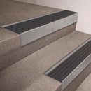 Mill Aluminium finish 66x55mm raked back aluminium stair nosing with a Nimbus Castellated insert, fitted to interior steps
