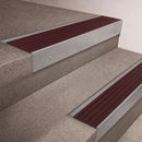 Mill Aluminium finish 66x55mm raked back aluminium stair nosing with a Regency Castellated insert, fitted to interior steps