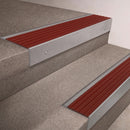 Mill Aluminium finish 66x55mm raked back aluminium stair nosing with a Rustic Castellated insert, fitted to interior steps
