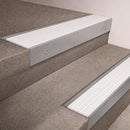 Mill Aluminium finish 66x55mm raked back aluminium stair nosing with a White Castellated insert, fitted to interior steps
