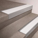 Mill Aluminium finish 66x55mm raked back aluminium stair nosing with a White Castellated insert, fitted to interior steps