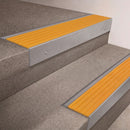 Mill Aluminium finish 66x55mm raked back aluminium stair nosing with a Yellow Castellated insert, fitted to interior steps