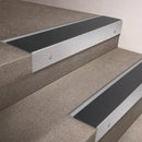 Satin Aluminium finish 66x55mm raked back aluminium stair nosing with a Black Anodised Aluminium insert, fitted to interior steps
